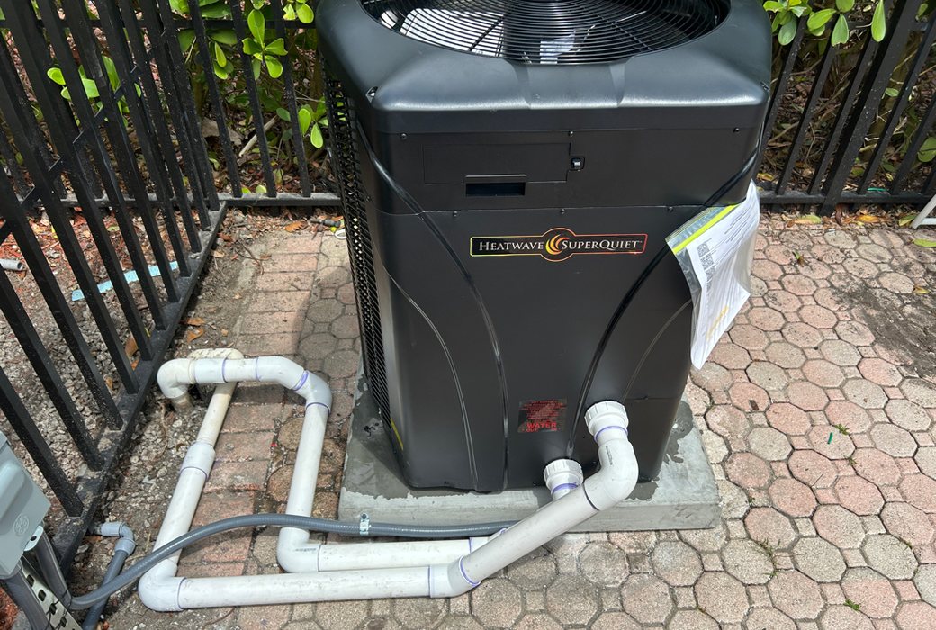 A new pool heat pump on a paver pad with open space around it