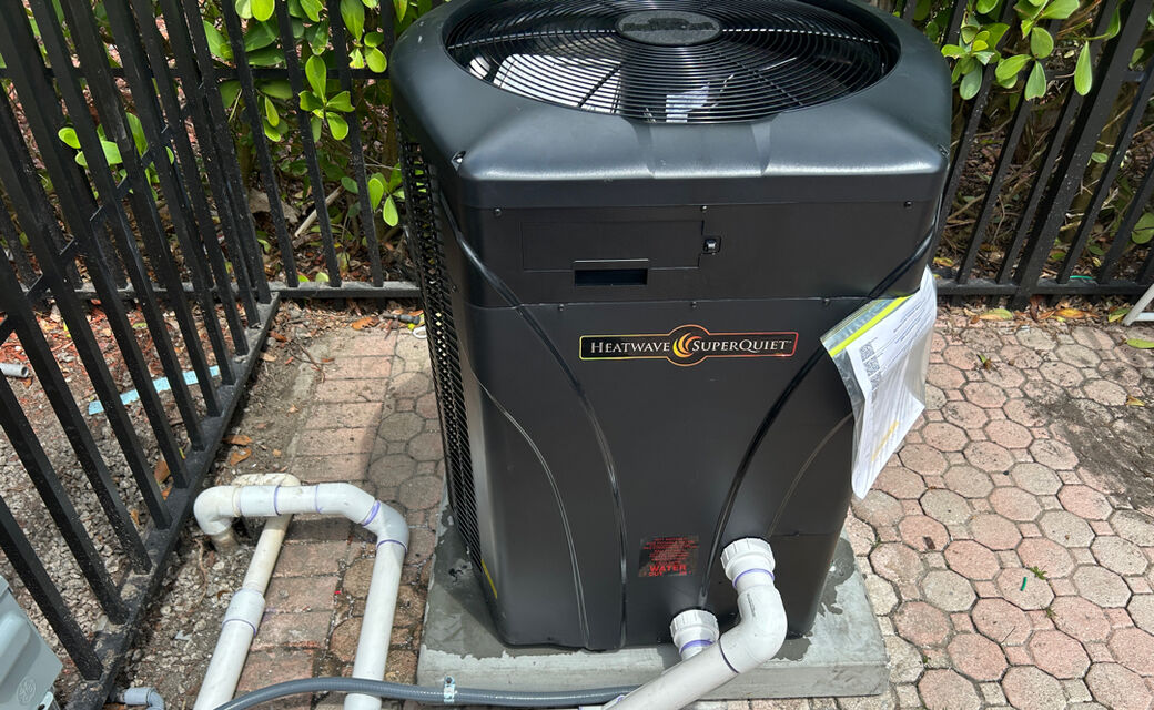 A new HeatWave SuperQuiet pool heat pump on a paver pad