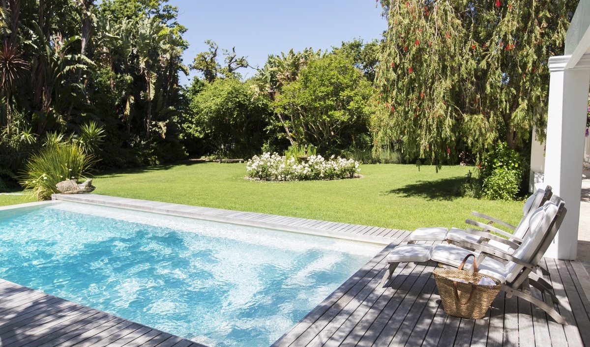 A backyard pool beside a green lawn