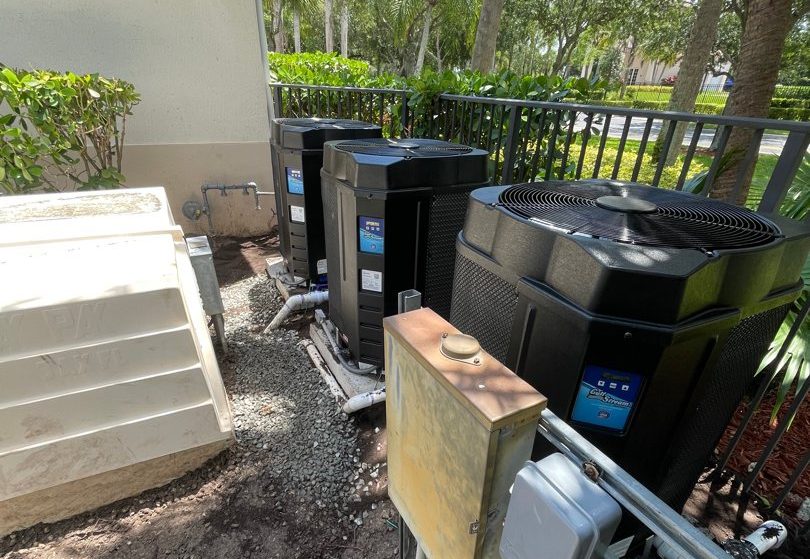 New Gulfstream heat pumps lined up on a community pool equipment pad