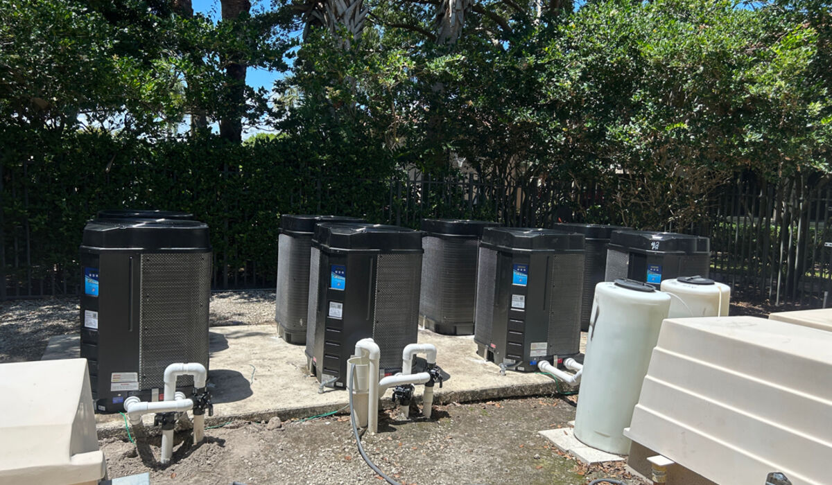 Six new pool heat pumps in a row at a community pool equipment pad